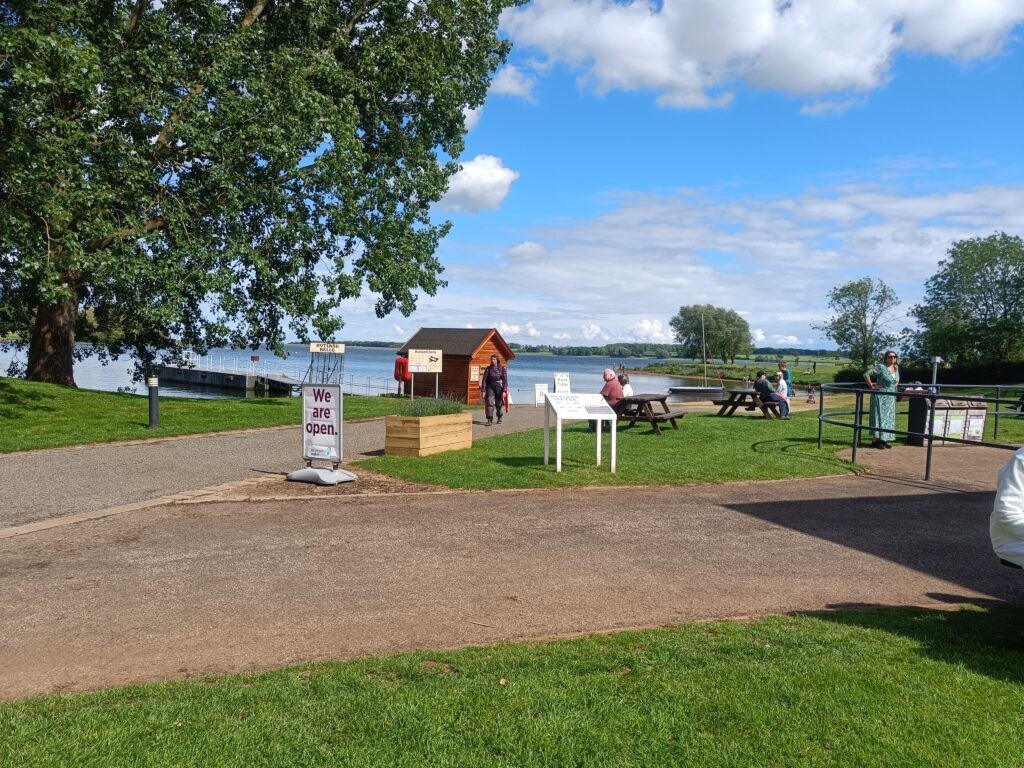 Whitwell Creek, a wide view of the reservoir with trees and tarmac roads in the foreground.