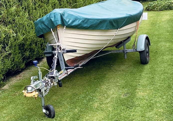 A sailing dinghy on a road trailer.