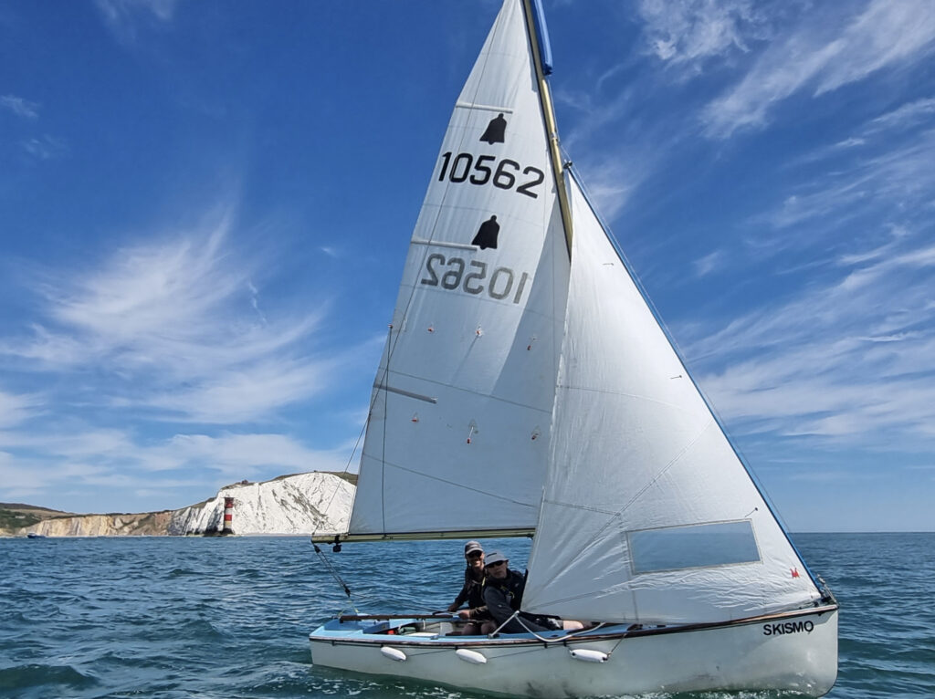 A picture of a GP14 sailing in front of the 'Needles' on the Isle of Wight