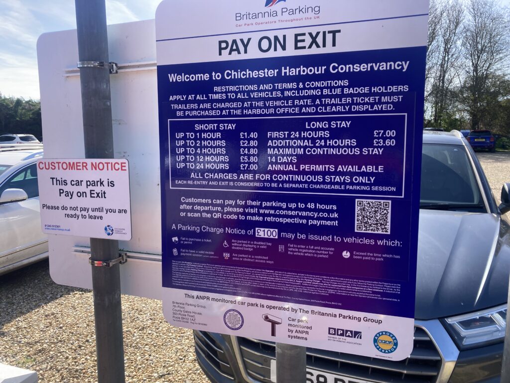 A picture of the Pay On exit pricing board in the carpark at Itchenor