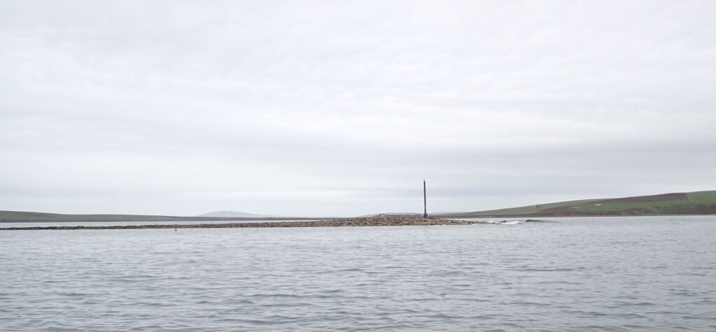 Photograph of the spit at the entrance to St Margaret's Hope bay - the deep water is to the East of the pole. This is at low tide.