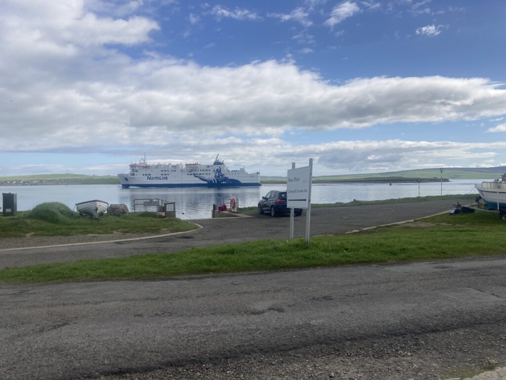 Photograph of the Stromness SC Slipway with the ferry passing into Stromness port.